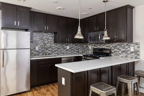 A kitchen with dark wood cabinets and a white countertop.