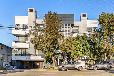 A modern building with a parking lot in front.