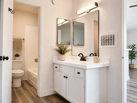 A white bathroom with a toilet, sink, and mirror.