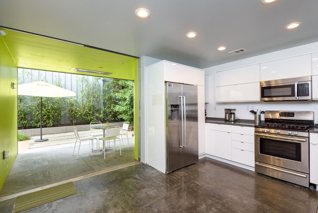 a kitchen with stainless steel appliances and a table and chairs