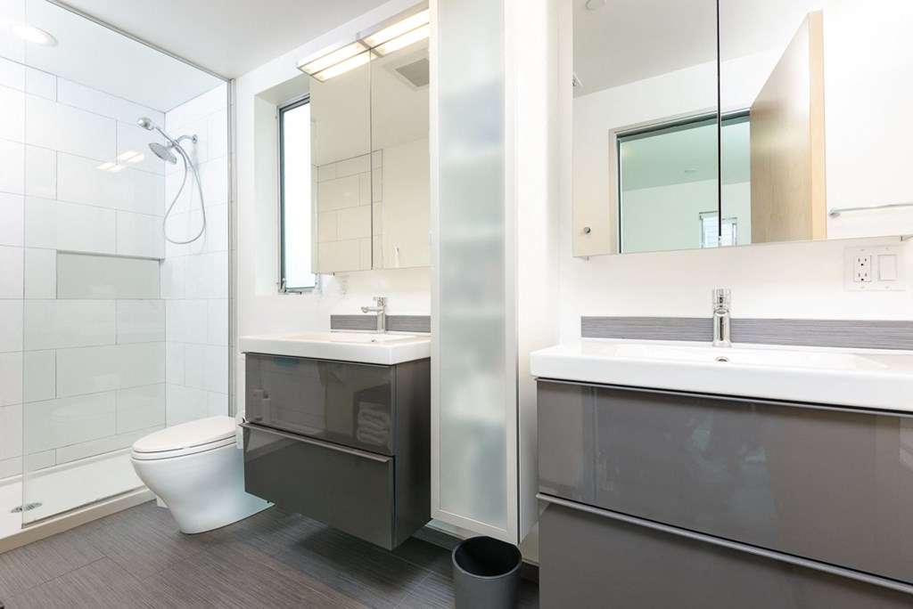 a bathroom with a toilet sink and mirror and a shower