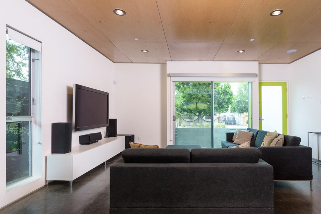 a living room with a black couch and a television