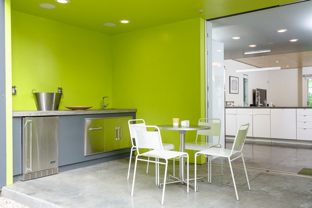 a kitchen with green walls and a table and chairs