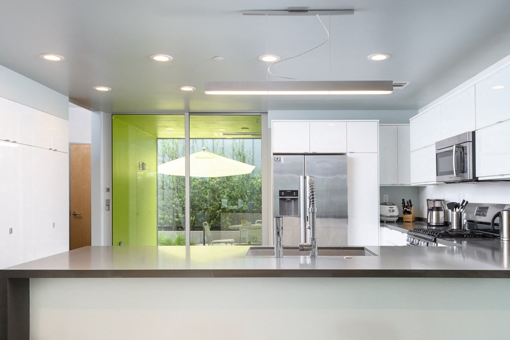 a kitchen with white cabinets and a counter and a window