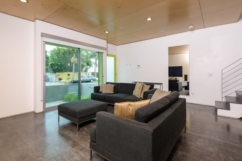 a living room with a couch and a chair in front of a window