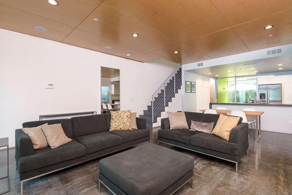 a living room with two couches and a table and a staircase