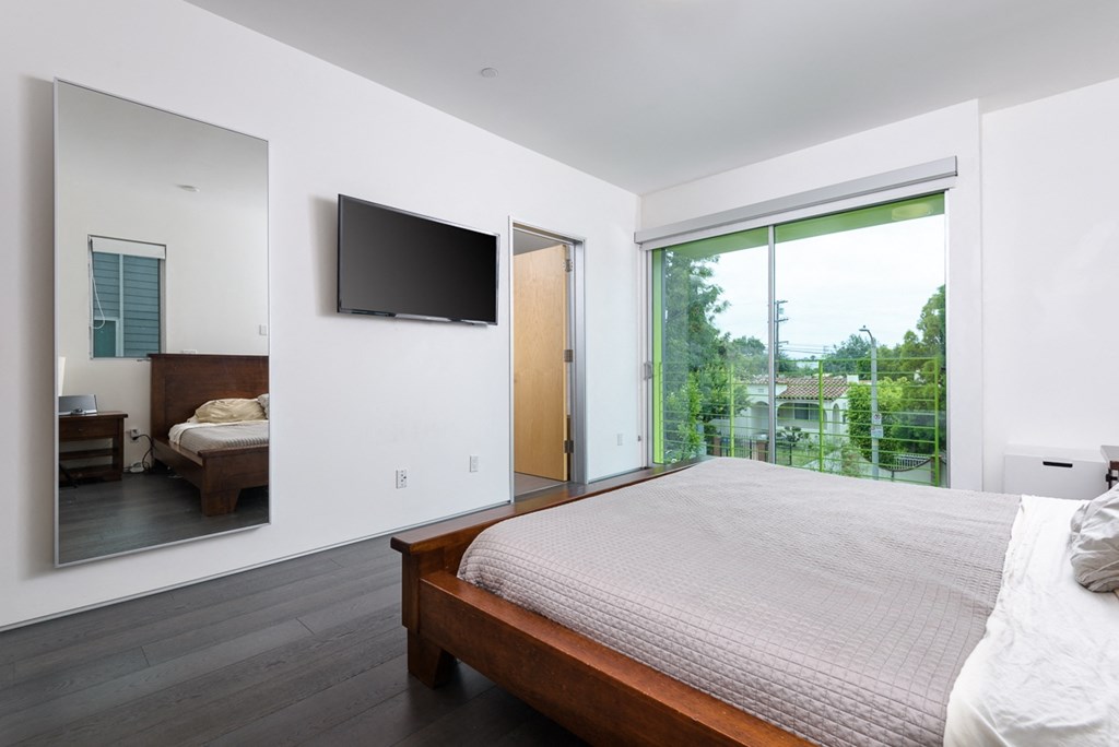 a bedroom with a large bed and a tv on the wall