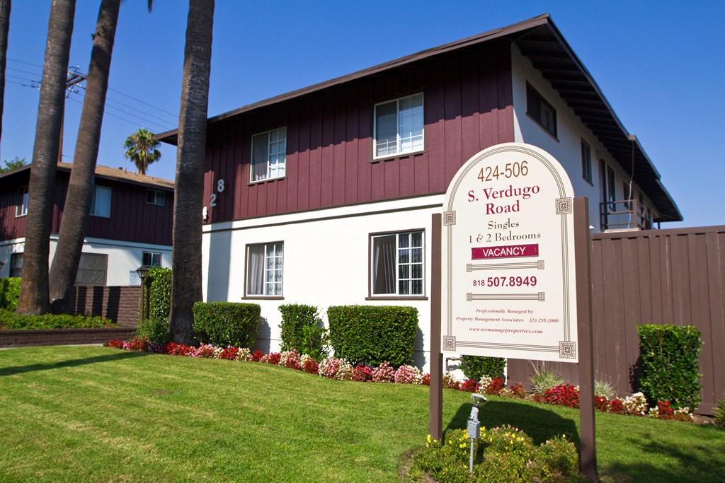 a red and white house with a sign in front of it