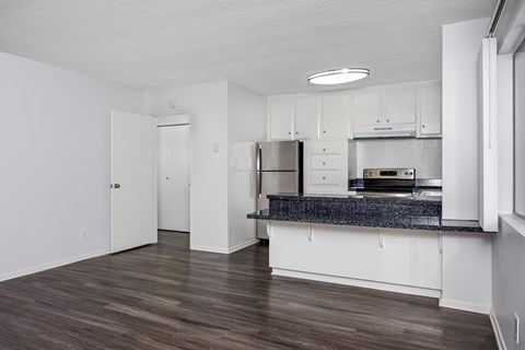 A kitchen with white cabinets and a granite countertop.