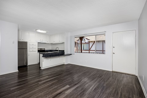 A kitchen with white cabinets and a black countertop.