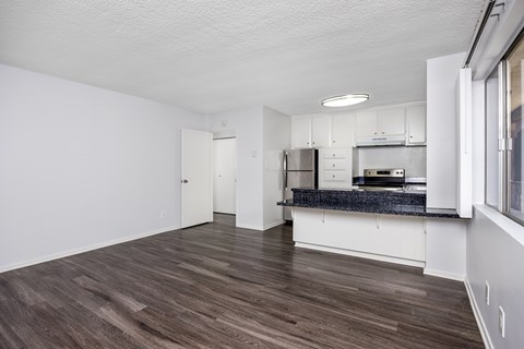 A kitchen with a refrigerator, microwave, and oven is visible.