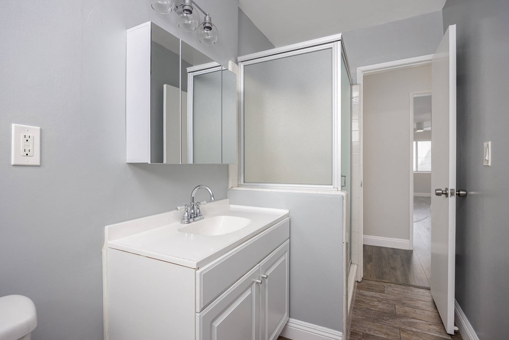 a white bathroom with a sink and a mirror