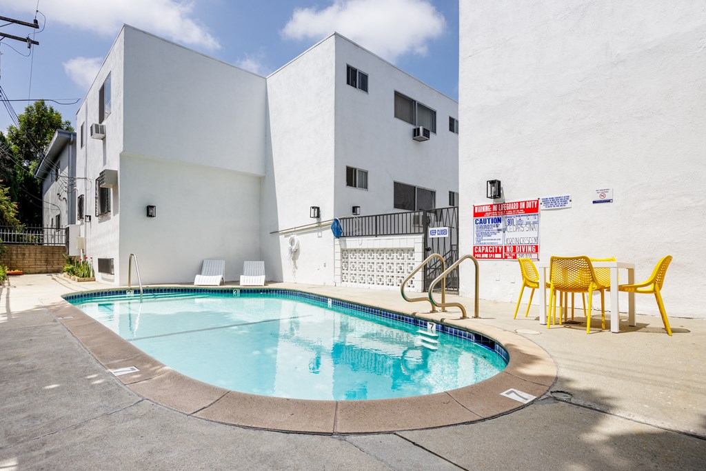 the pool of a building with yellow chairs and a swimming pool