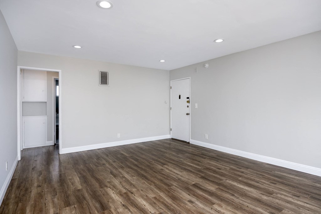 a living room with white walls and wood floors