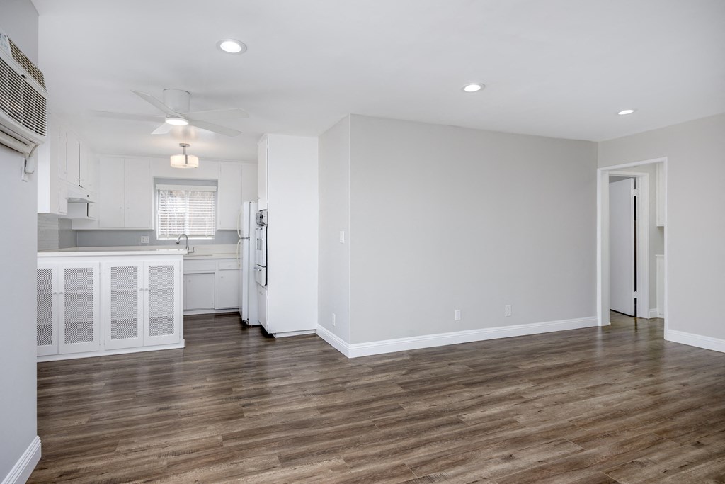a living room with a kitchen and a ceiling fan