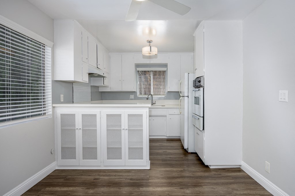 a renovated kitchen with white cabinets and white appliances