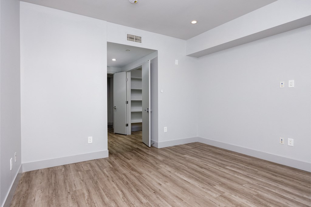 a living room with white walls and a wooden floor