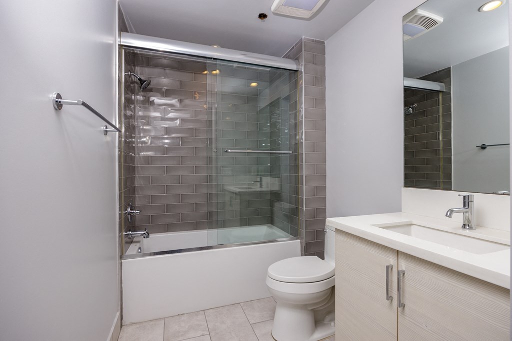 a bathroom with a shower and a toilet and a sink