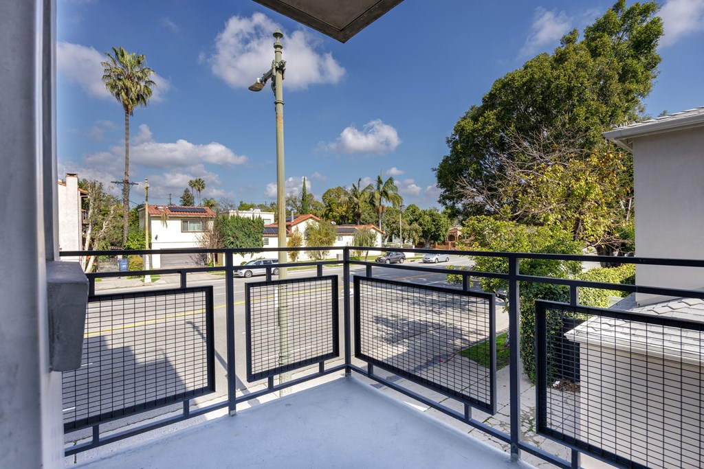 the balcony has a view of the city and palm trees