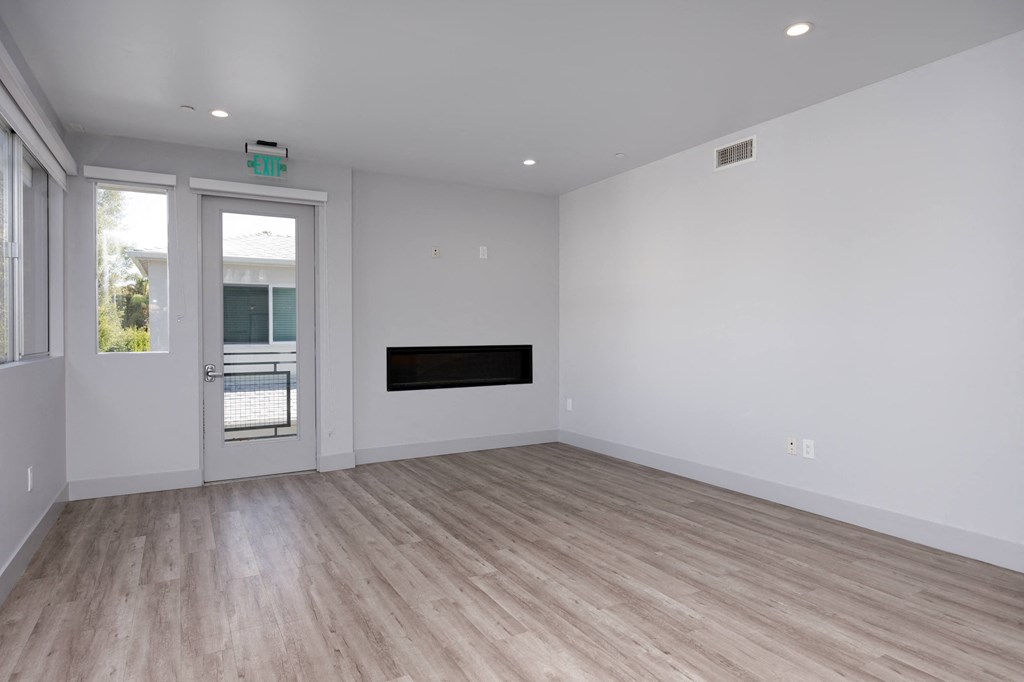 a living room with white walls and a tv on the wall