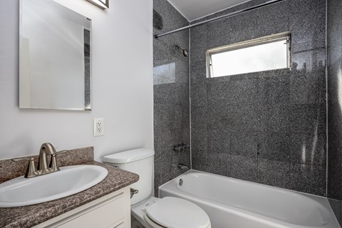 A bathroom with a sink, toilet, and bathtub.