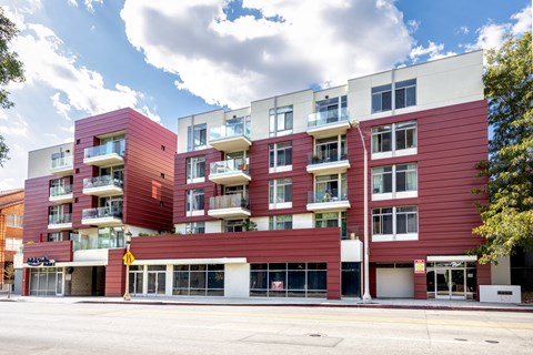 a red apartment building on the corner of a street