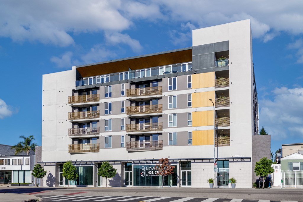 a white building with balconies and a street in front of it