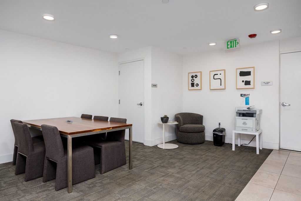 a conference room with a table and chairs and a refrigerator