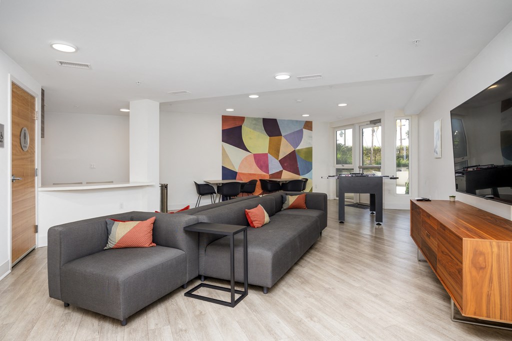 a living room with a gray couch and a dining room table