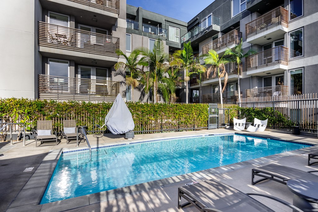 a swimming pool in an apartment building with palm trees