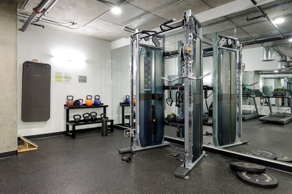 a fitness room with cardio equipment and weights