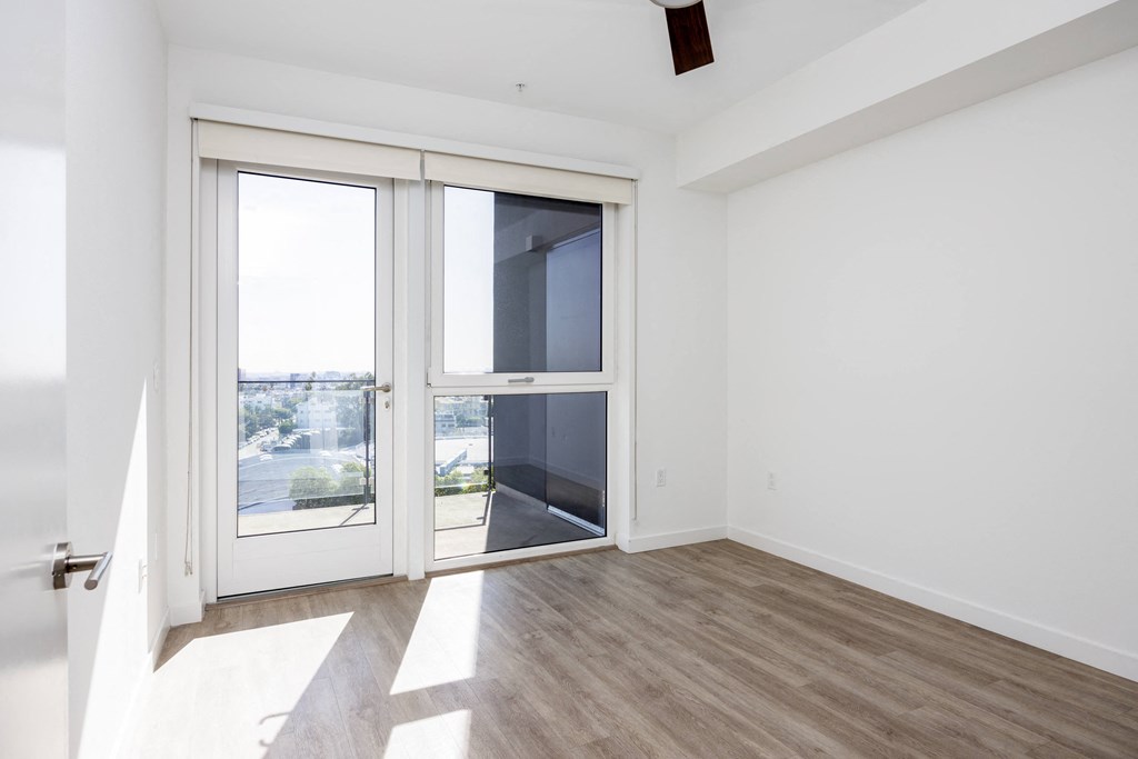 an empty living room with a door to a balcony