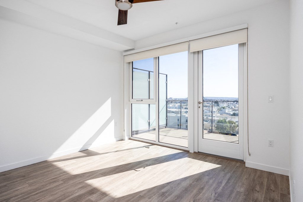 a living room with glass doors and a view of the city