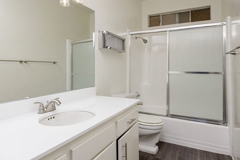 a white bathroom with a shower sink and toilet