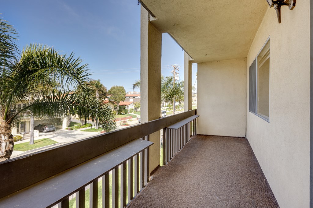 a balcony with a view of the street and palm trees