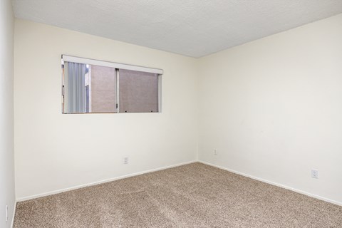 an empty room with carpet and a window