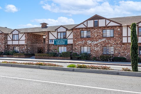 The Chateau is a large brick building with a green lawn in front.
