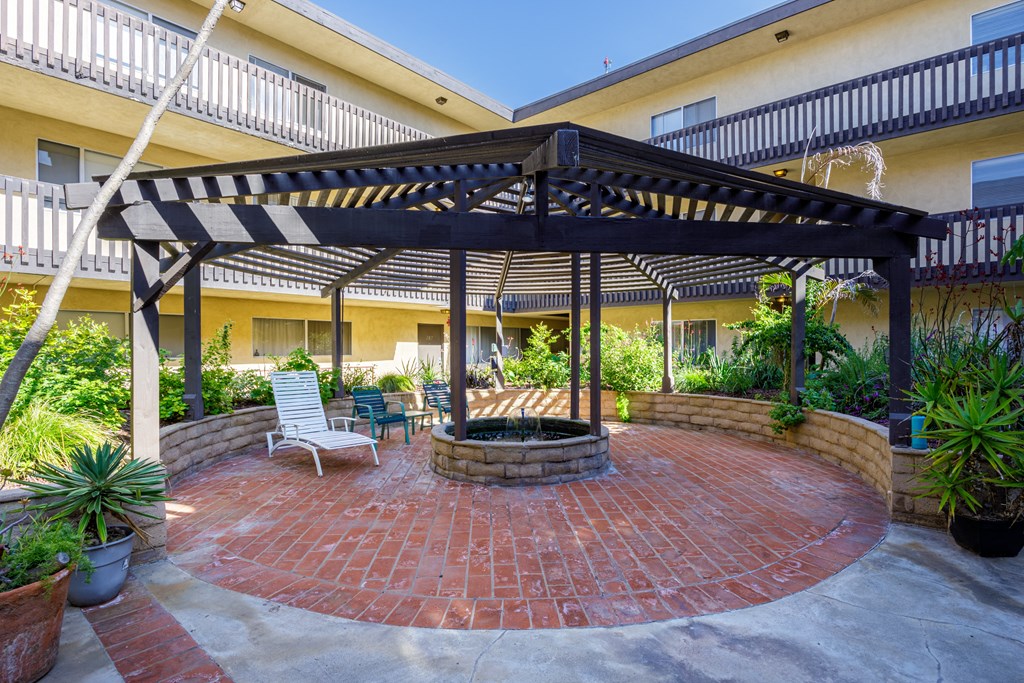 a patio with a fire pit and a gazebo