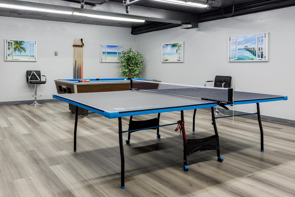 a ping pong table in a room with two chairs