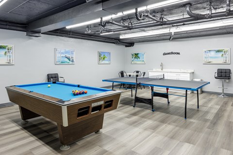 two pool tables and two ping pong tables in a room with other tables