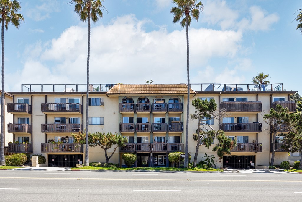 a large apartment building with balconies and palm trees