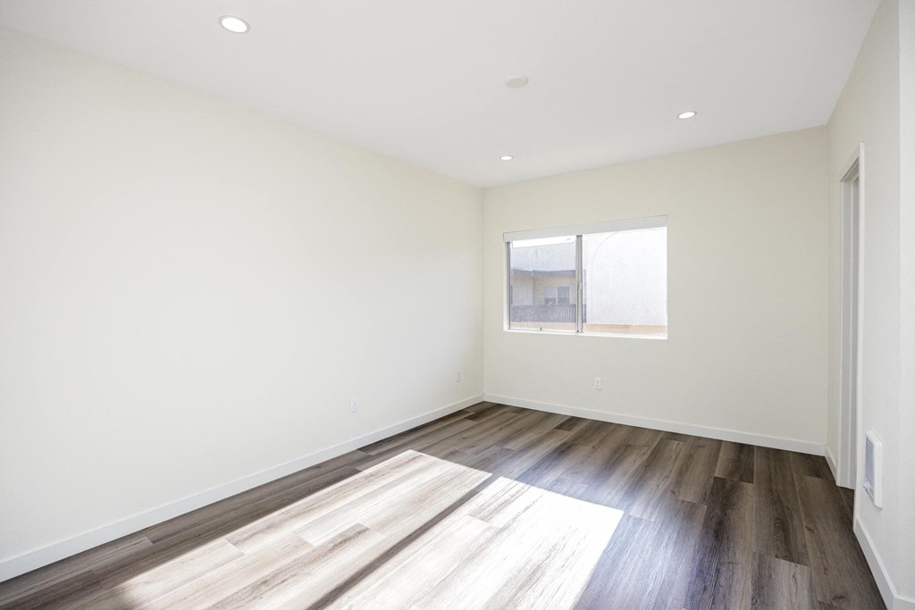 an empty room with wood floors and a window