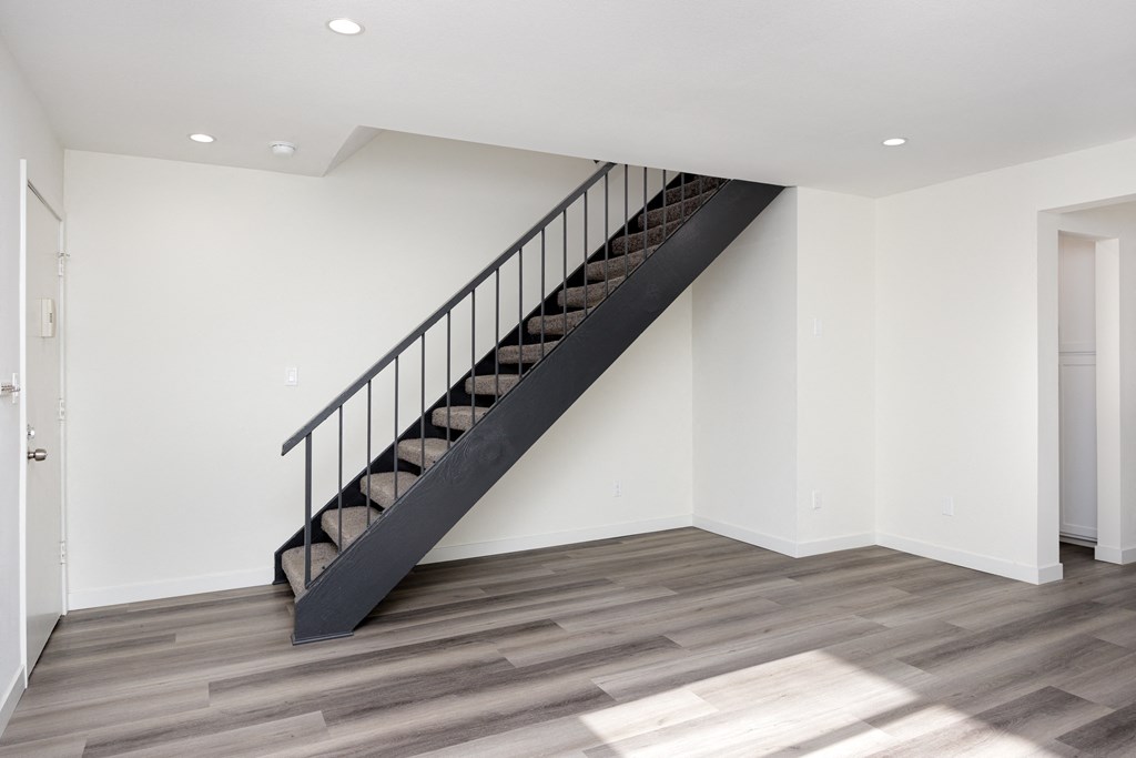 a staircase in a home with white walls and wood floors