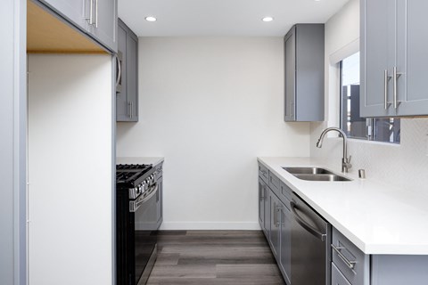 a kitchen with white countertops and stainless steel appliances