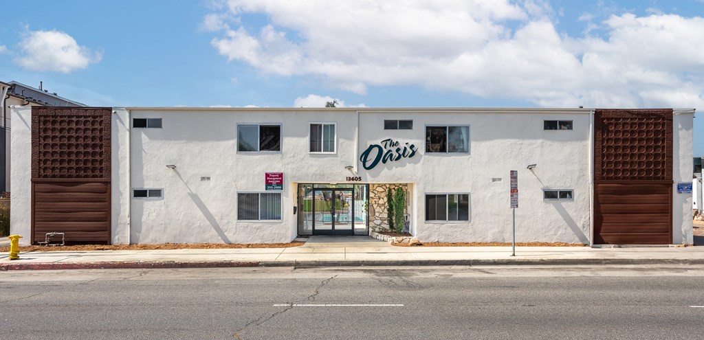 a white building with a sign on it on the side of a street