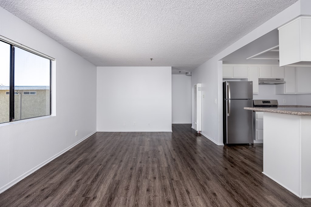 A kitchen with white cabinets and a refrigerator.