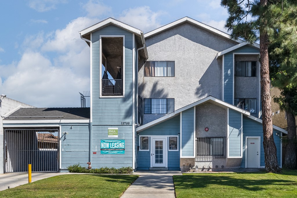 A blue house with a sign that says "Now Leasing".