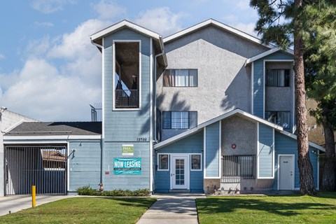 A blue house with a sign that says "Now Leasing".