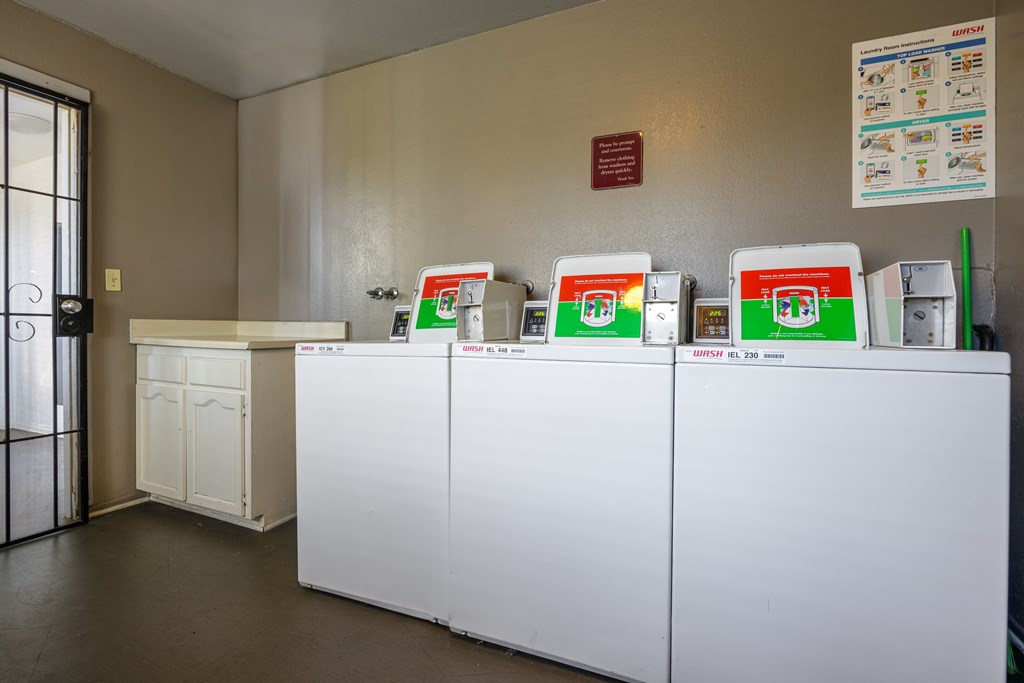 A row of washing machines are lined up in a laundromat.
