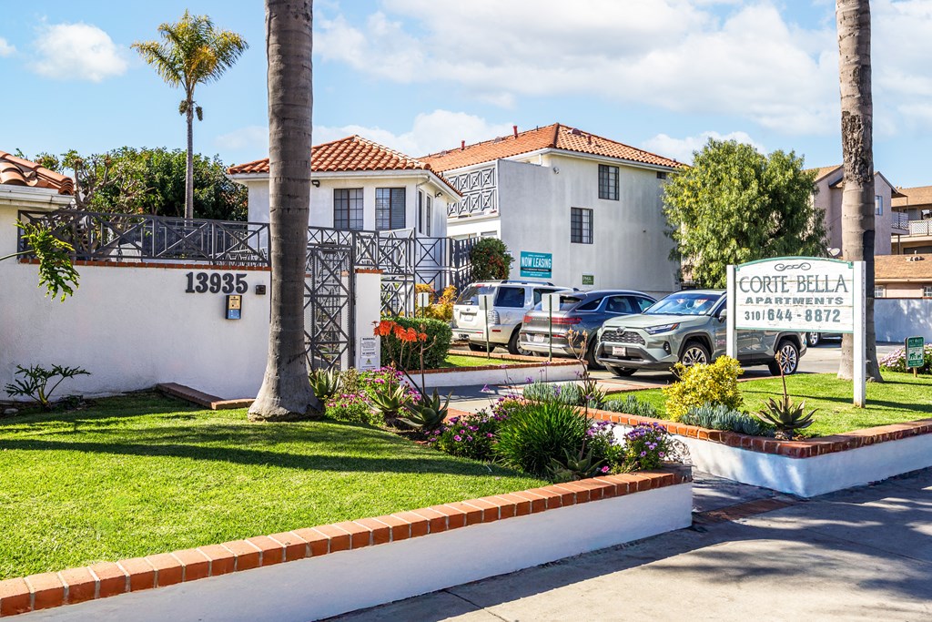A white building with a sign that says Corte Bella in front of it.
